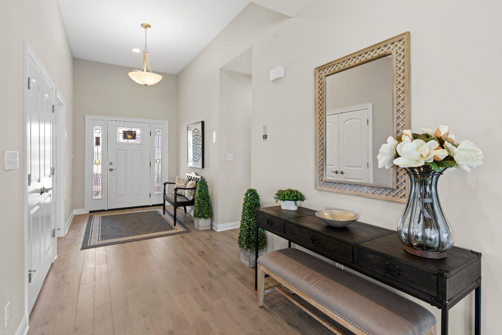 Modern foyer featuring bench and chandelier