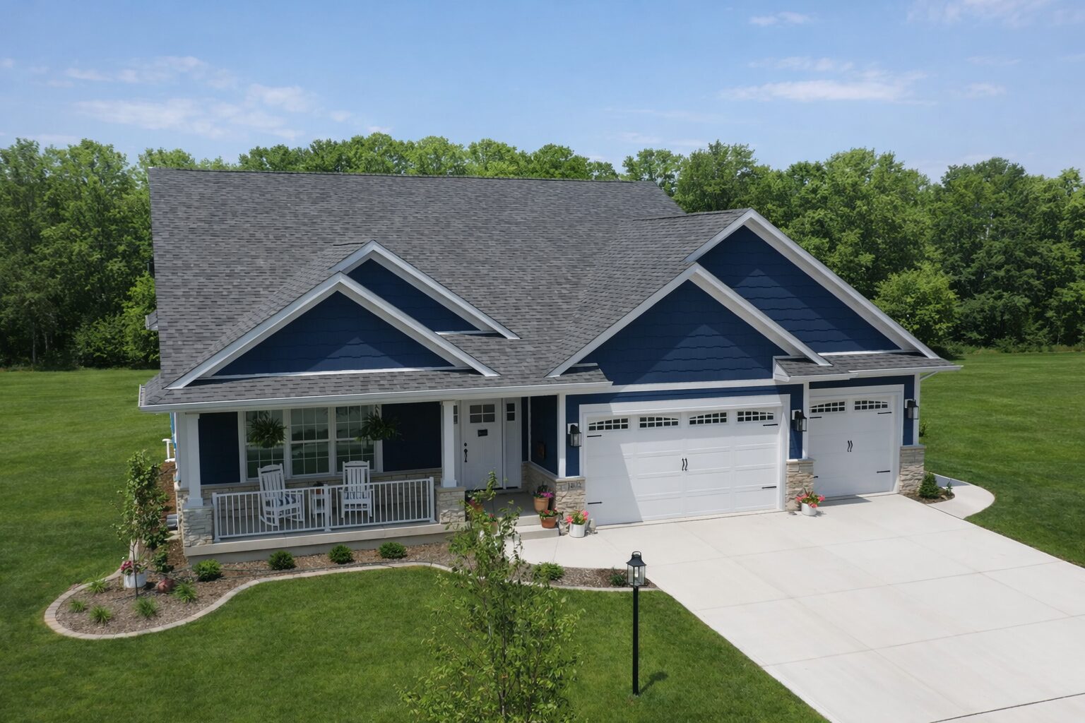 Blue house with garage and green lawn.