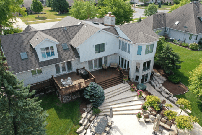 Large house with deck and landscaped yard.